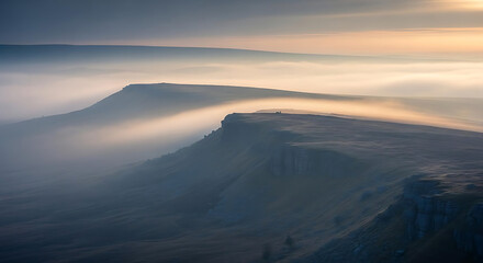 A serene mountain landscape with fog rolling in at sunrise