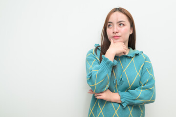 Portrait of a young Asian woman against white background thinking