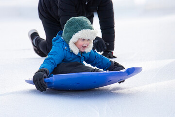 Mom Pushes Little Boy on Sled