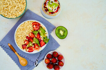 Delicious overhead view of a healthy oatmeal and yogurt bowl topped with fresh sliced strawberries and vibrant kiwi fruit pieces for breakfast