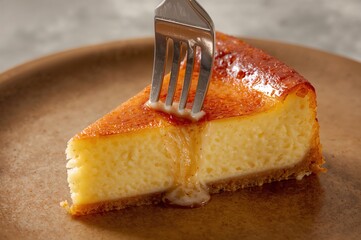 Soft light warms caramelized crust as creamy cheesecake yields gently beneath the fork