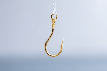 Gold hook is hanging from a white string