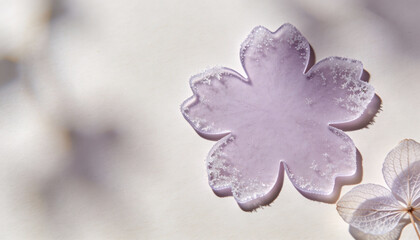 Pastel lilac flower silhouette in a soft and airy mood with frost-textured polymer and spacious negative space for editorial or commercial use
