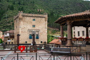 A sign with the word Potes on it is on a stone wall. The sign is surrounded by a fence and is located in front of a building
