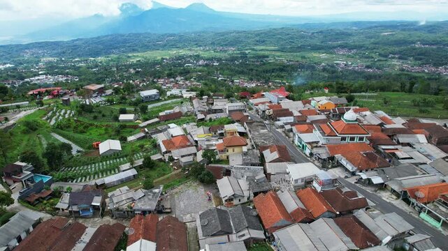 Aerial drone footage of Bandungan valley in Semarang region, Java island, Indonesia, on top of Songo temple, with many local houses 