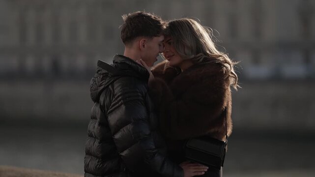A young couple embraces in a romantic moment in Paris France The man and woman share an intimate connection with soft natural lighting in an urban setting The clip captures the essence of love and tog