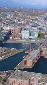 4K aerial vertical video of Liverpool Royal Albert Dock and Radio City Tower. Cinematic drone footage of Canning Dock, The Strand, and city skyline. Historic UK waterfront for mobile reels.