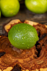wet ripe citrus limes scattered on the wooden table in the kitchen, ripe and juicy lime fruits for cooking