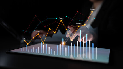 A digital tablet displays vibrant graphs and charts in a dark setting, representing business analytics and the financial decision-making process for professionals. Scalp