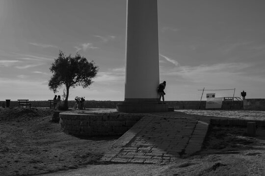 Une femme se cache derri&egrave;re un phare dans un parc pr&egrave;s de l'oc&eacute;an Atlantique de la ville de Saint Martin en R&eacute; sur l'&icirc;le de R&eacute; 