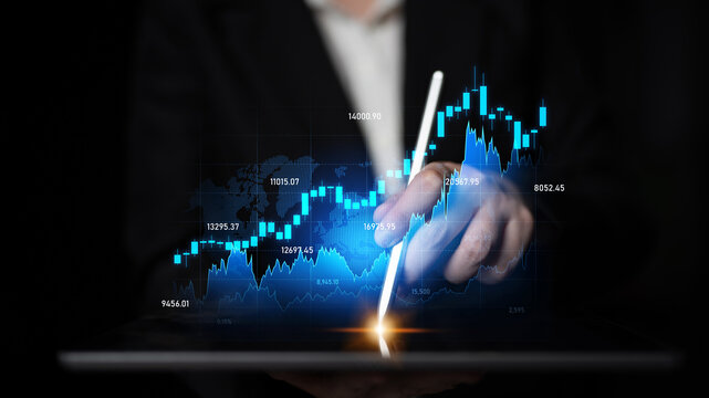 A businessman focuses on financial analysis through a tablet, showcasing stock market graphical data and trends in a dark office setting, emphasizing technology and modernity. Scalp - Powered by Adobe