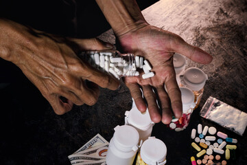 Image depicts a serious situation showing wrinkled hands spilling white pills from a container into an open palm, emphasizing themes of substance abuse, prescription misuse.
