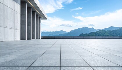 Fototapeta premium Modern concrete building with pillars, overlooking a mountain range and sunny sky