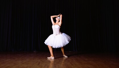 Ballet dancer performs on stage during a dance recital in a theater at night