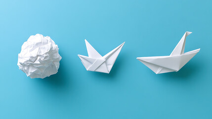 From crumpled paper to crafted origami: a creative journey unfolds. White paper transforms into a graceful form against a serene blue backdrop. Simplicity meets artistry.