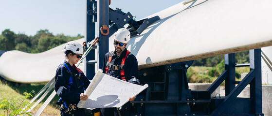 Professional wind turbine engineers preparing and inspecting equipment for installation and maintenance at a renewable energy site, teamwork, clean power, and sustainable technology.