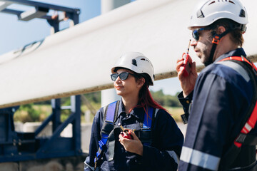 Professional wind turbine engineers preparing and inspecting equipment for installation and maintenance at a renewable energy site, teamwork, clean power, and sustainable technology.