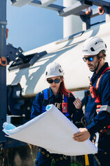 Professional wind turbine engineers preparing and inspecting equipment for installation and maintenance at a renewable energy site, teamwork, clean power, and sustainable technology.