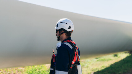 Professional wind turbine engineers preparing and inspecting equipment for installation and maintenance at a renewable energy site, teamwork, clean power, and sustainable technology.