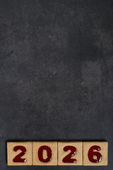 New Year 2026. Square cookies with red marmalade filling in the shape of the numbers 2026. Dark gray background. Copy space