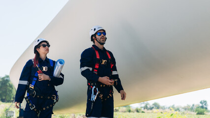 Professional wind turbine engineers preparing and inspecting equipment for installation and maintenance at a renewable energy site, teamwork, clean power, and sustainable technology.
