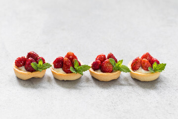 Mini dessert. Mini Wild Strawberry tartlets. Light background. Close up. Copy space	
