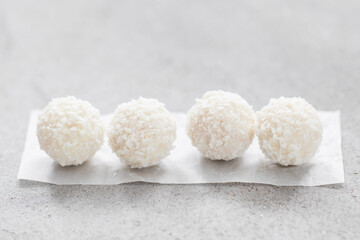 Vegan Coconut candy ball with whole almonds inside. On paper. On a light background. Close-up
