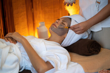 Serene ambiance of spa salon, woman customer indulges in rejuvenating with charcoal face cream...