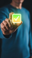 A person s hand interacting with a glowing futuristic green checkmark symbol in a dark environment