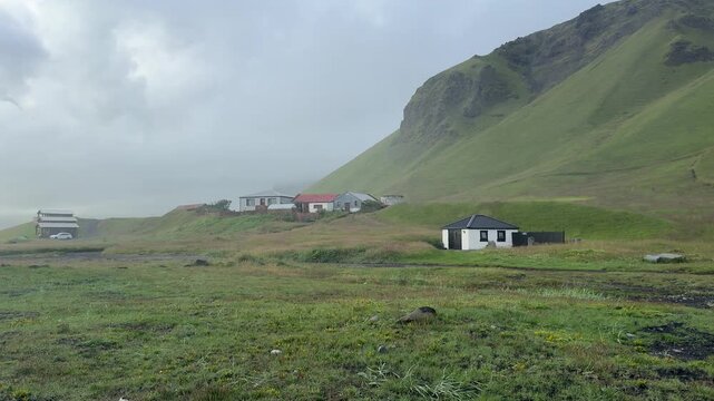 Icelandic Turf Houses on Green Hillside near Ocean