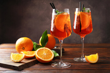 Fototapeta premium Glasses of refreshing spritzer cocktail and oranges on wooden table