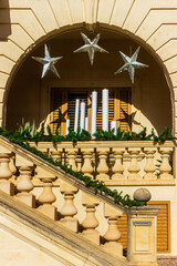 Elegant Balcony Archway With Candles, Silver Stars, And Greenery On Stately Staircase