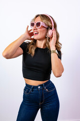 Naklejka premium Woman enjoying music listening with pink headphones and sunglasses
