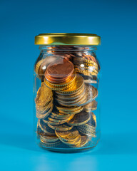 A closed transparent jar containing euro cents.