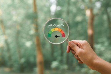hand holding a magnifying glass to check the good air quality and clean outdoor air quality safe from pollution dust PM 2.5 