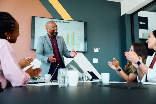 Confident businessman in smart casual presenting company growth data in boardroom at office