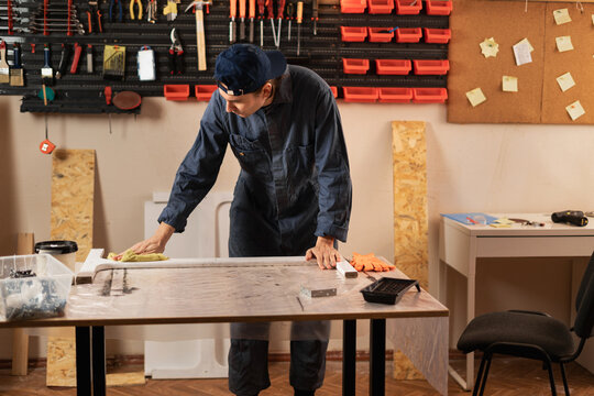 Male carpenter with workbench at workshop in timber project. woodworker making wooden repair restoration at construction warehouse - Powered by Adobe