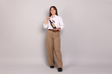 Professional sommelier opening bottle of wine on light grey background
