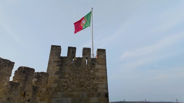 Portuguese flag flying above medieval castle walls
