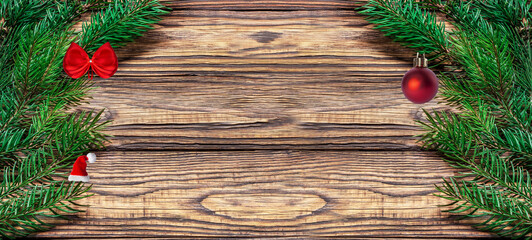 Christmas wooden background with a red Christmas ball and fir branches. Top view, flat lay, space for text.