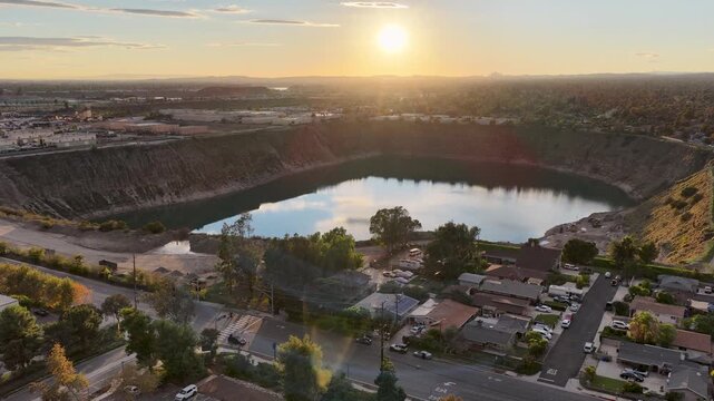Aerial footage of a lake surrounded by homes and lush green trees at sunset in Duarte California USA