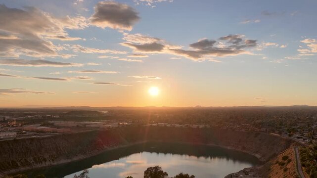 Aerial footage of a lake surrounded by homes and lush green trees at sunset in Duarte California USA