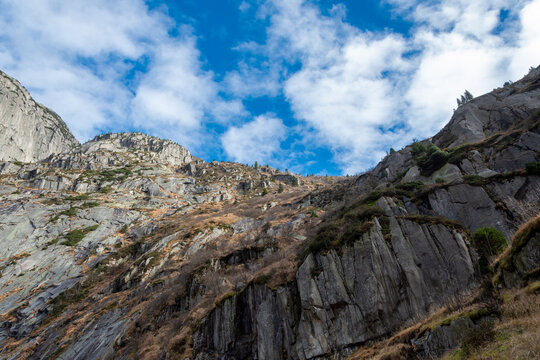 Falaises rocheuses alpines sous un ciel bleu parsem&eacute; de nuages