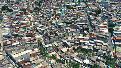 Vis&atilde;o a&eacute;rea de &aacute;rea densamente ocupada por moradias populares, mostrando desigualdade social, urbaniza&ccedil;&atilde;o informal e a complexidade do espa&ccedil;o urbano.