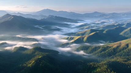 Aerial view of a mountain range partially shrouded in mist during the early morning hours