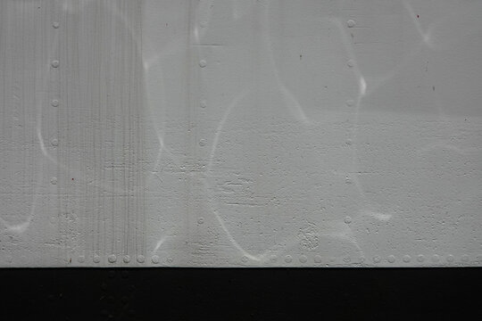 A textured surface features light reflections and subtle patterns of water caustic.