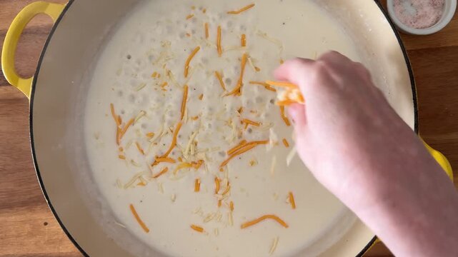 Closeup of Adding Cheese to Bechamel Sauce to Make a Cheese Sauce