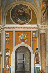  the Cathedral of Saint George in Ano Syros showcasing  columns, arches, and a vaulted ceiling with intricate artwork. The central altar is draped in white cloth and framed by golden columns 