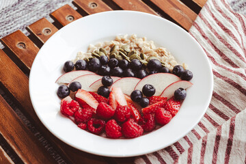 a plate of fresh fruits, homemade granola and berries, cafe style breakfast meal at home