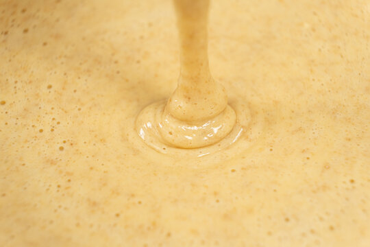 Texture of smooth creamy batter flowing down.